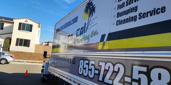 A moving company truck parked near houses on a sunny day.