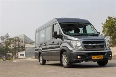 A grey Lohia minibus parked outdoors on a paved surface.