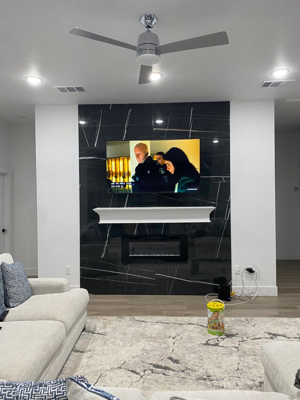 TV mounted over fireplace in living room.