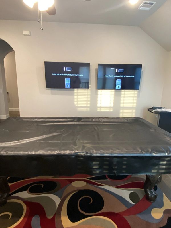 Two tv's mounted in pool room.