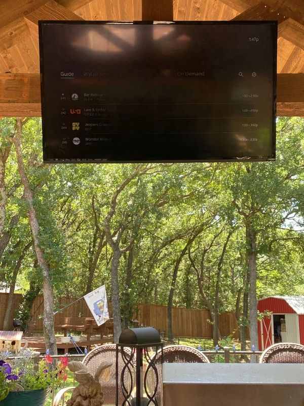 TV mounted under pergola.