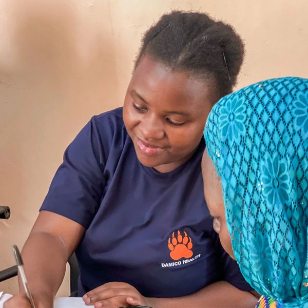 Healthcare worker assisting a woman with paperwork.