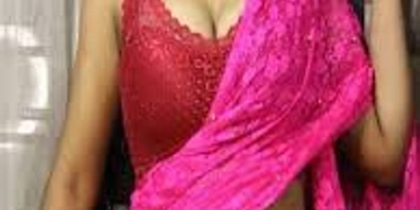 Woman wearing a red blouse and pink saree.