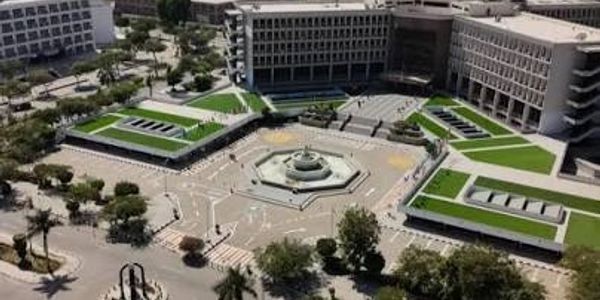 Modern courtyard with central fountain and surrounding buildings.