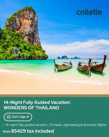 Scenic beach with traditional boats and limestone cliffs in Thailand.