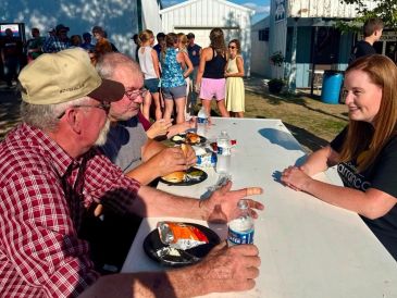 People enjoying a meal at an outdoor event.