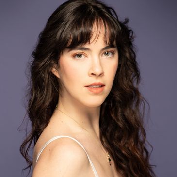 Portrait of a woman with long wavy hair and bangs.