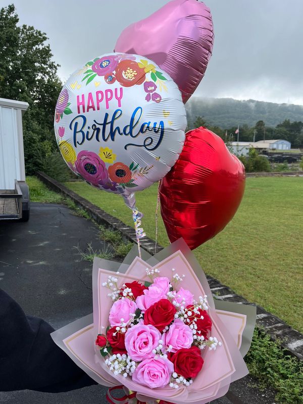 Colorful birthday bouquet with balloons outdoors.