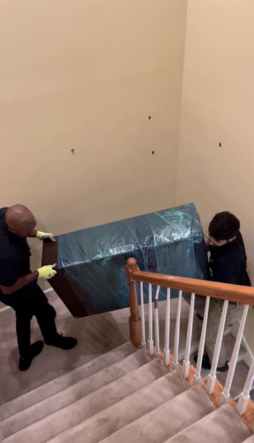 Our crew of expert movers carrying a dresser down stairs in Vinings Georgia