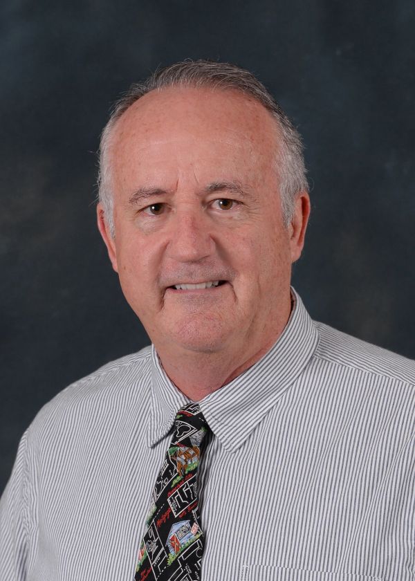 Portrait of a mature man in a striped shirt and colorful tie.