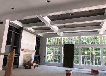 Spacious living room under construction with large windows.