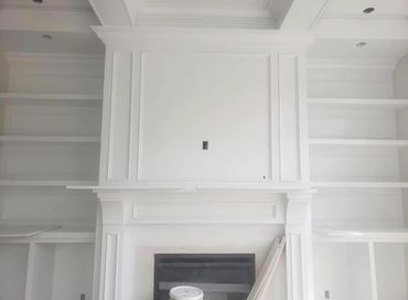 Empty white built-in wall shelves and fireplace.