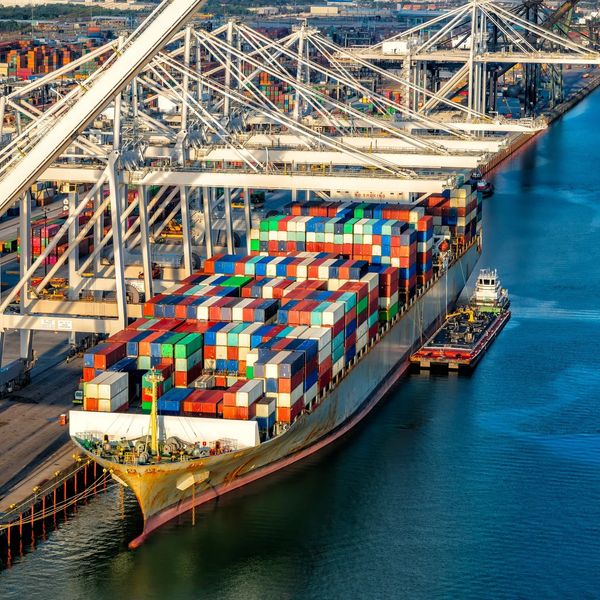 Large cargo ship loaded with colorful containers at port.
