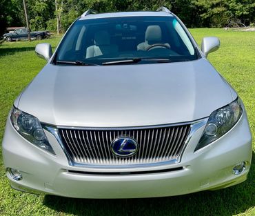 Front view of a silver Lexus SUV parked on grass.