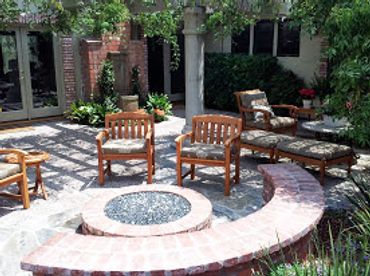 Built in round gas, fire pit with glass, stone and brick. Traditional, southern California backyard
