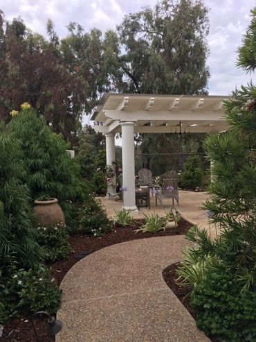 Contemporary white pergola with exposed aggregate, concrete.