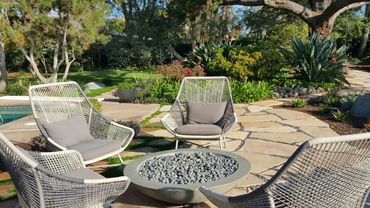 Built in gas, round concrete fire pit round with rocks.