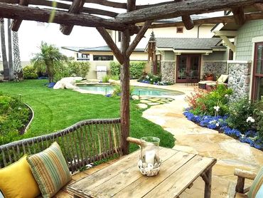 Natural Wood Pergola, swimming pool, flower beds, grass, palm trees. Stone pathway,