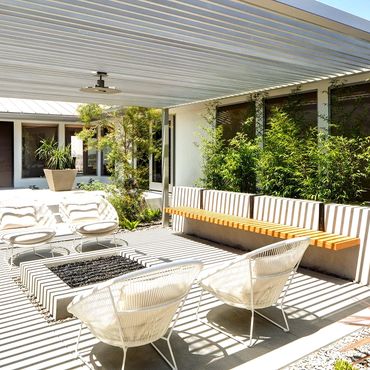 Contemporary slat patio cover with built in fit pit.