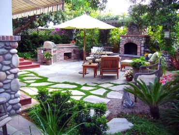 Outdoor Riverstone Fireplace and hearth. Outdoor kitchen and grill, seating area, stepping stones.