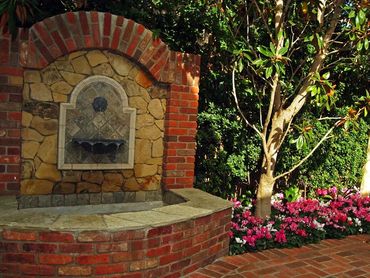 Brick and Stone water feature in San Diego, California. Flower beds, trees, brick pavers.