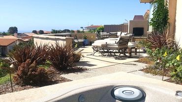 Hot tub and patio area with outdoor fireplace