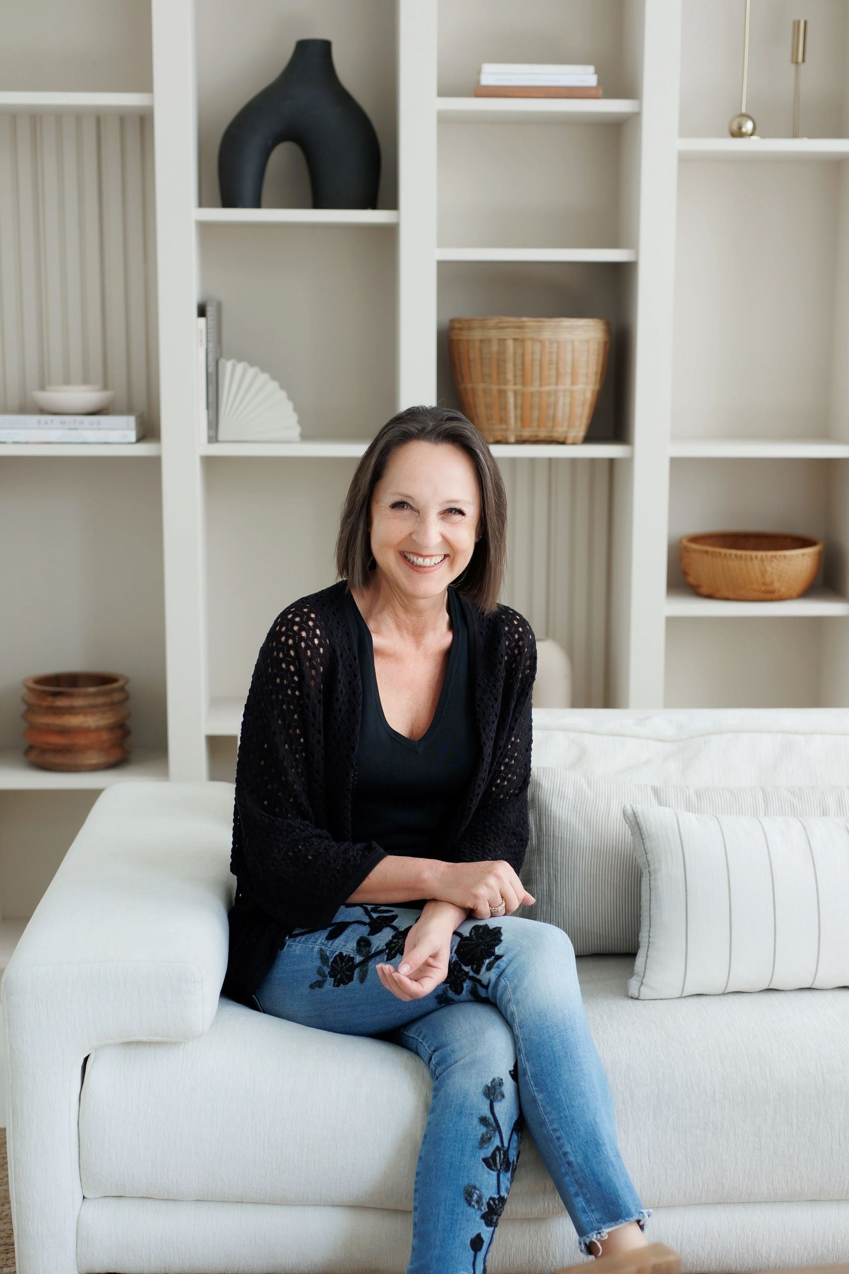 A woman smiling with **** on the sofa with looking ahead