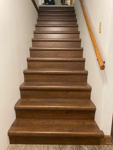 Wooden staircase with a handrail on the right side.