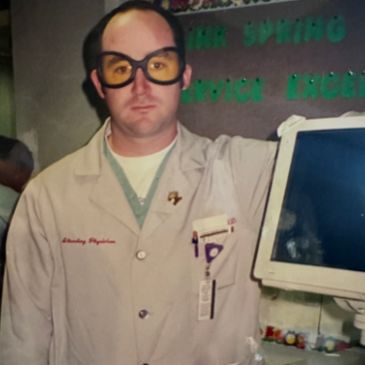 Man in a lab coat and yellow safety glasses.