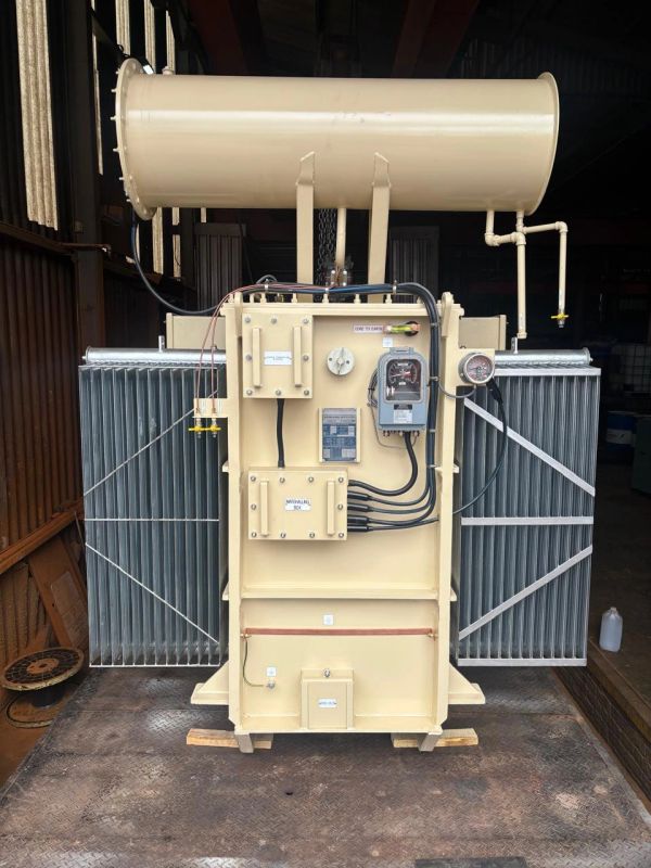 Industrial electrical transformer with cooling fins and control gauges.