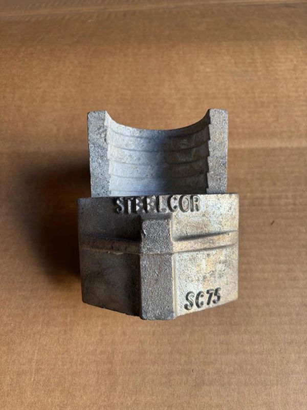 Metal casting mold labeled 'STERLICOR SC75' on a brown surface.