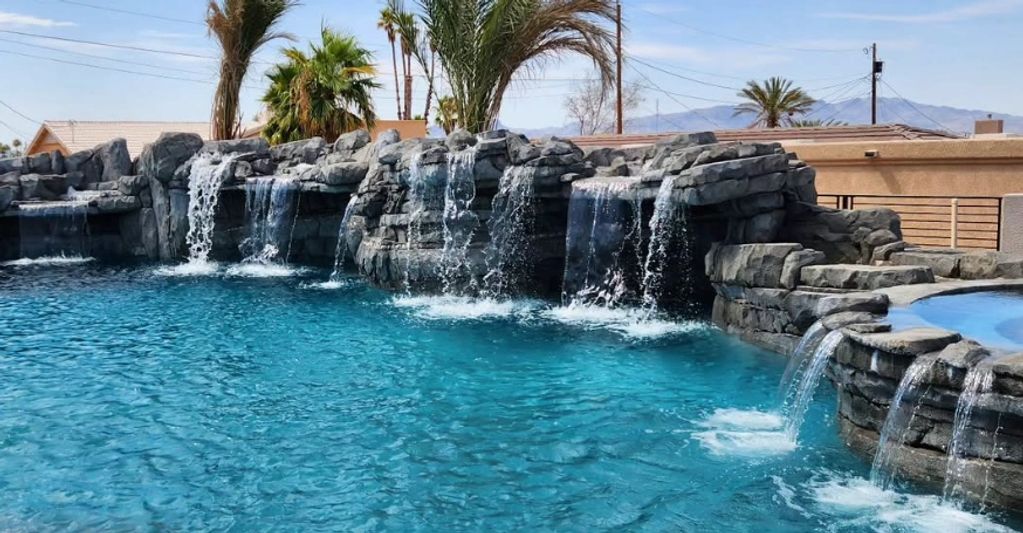 Pool with multiple waterfalls and rocks.