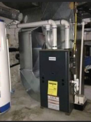 Basement with a water heater and furnace setup connected by pipes.