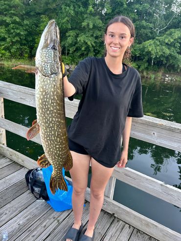 Dad helps his daughter catch a big Northern Pike fish