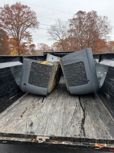 Two gray truck bed caps placed in the back of a pickup truck.