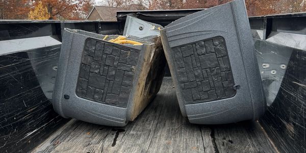 Two gray truck bed caps placed in the back of a pickup truck.