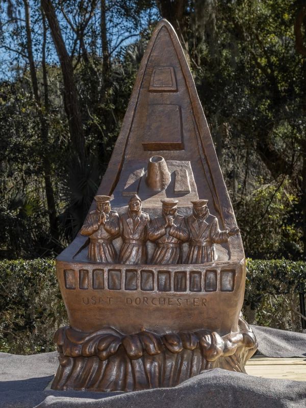 Bronze sculpture of USAT Dorchester ship with four figures.