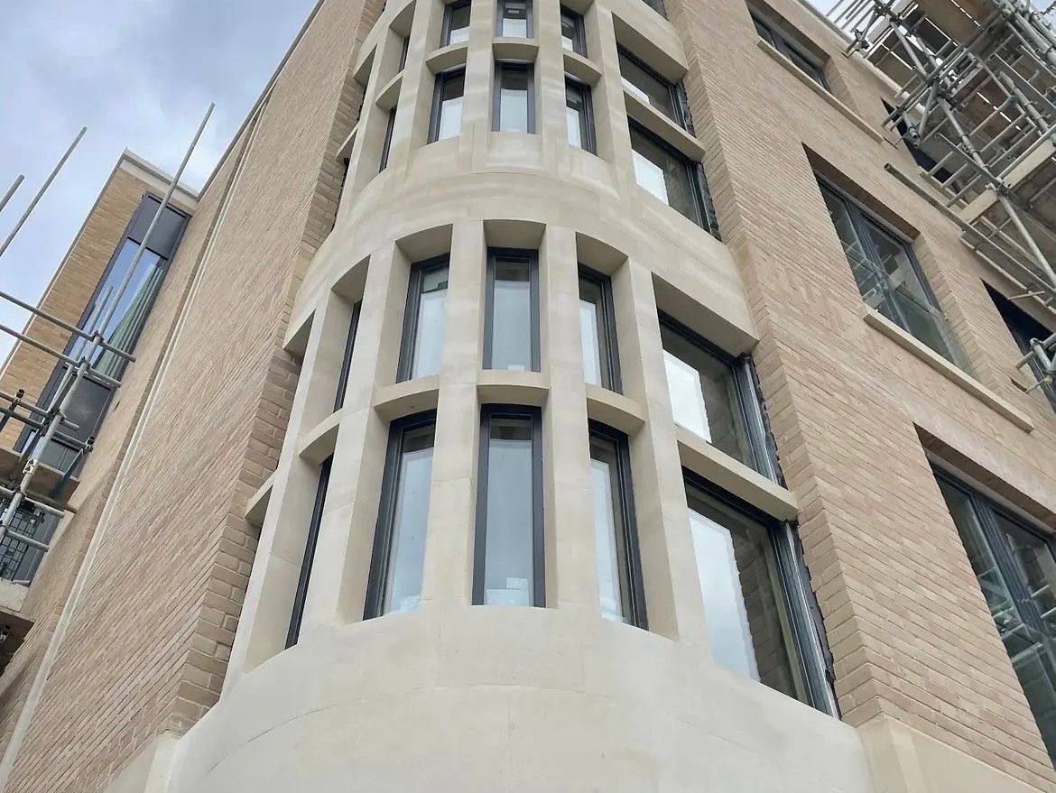 Modern building corner with vertical windows and scaffolding.
