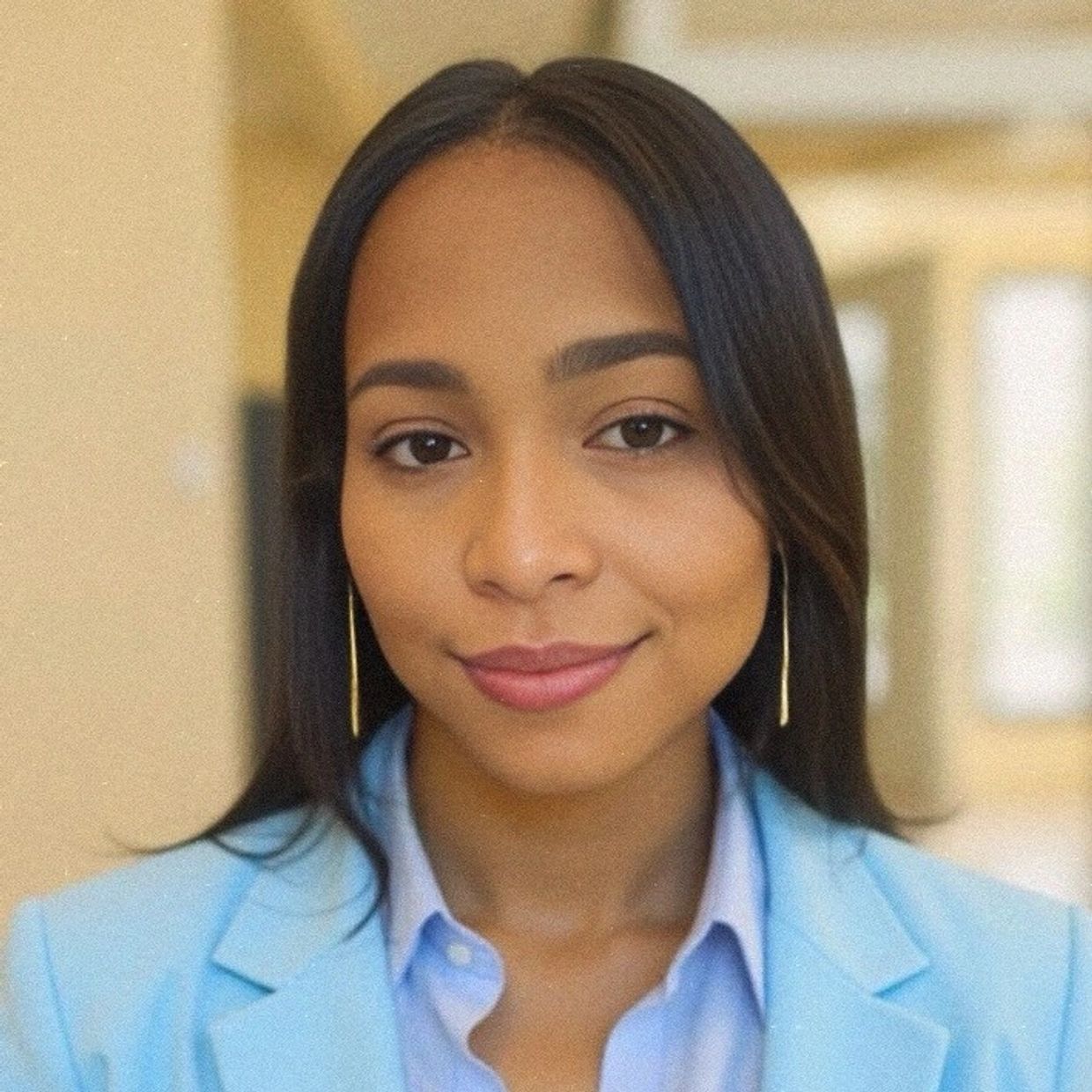 Confident woman in light blue blazer with Transformative Beginnings logo.