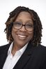 Smiling professional woman with glasses in business attire.