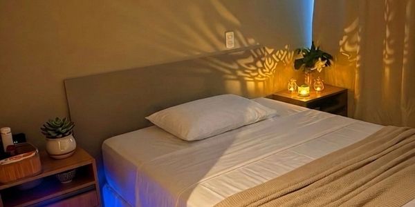 Quarto aconchegante com iluminação suave e decoração minimalista.