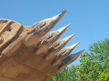 Large excavator bucket against sky.
