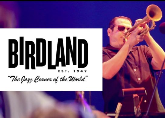 Musician playing trumpet at Birdland, jazz's iconic venue.