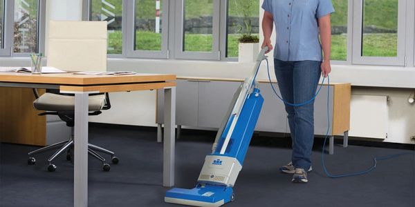 Technician vacuuming as part of Office Cleaning Service.