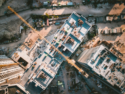 Aerial view of a construction site with buildings and a yellow crane.
