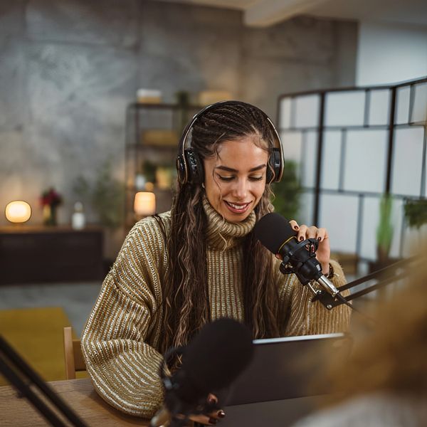 Woman recording podcast with headphones.