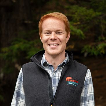A picture of James Woidt, PE - red hair in blue plaid shirt and black Redfish vest.