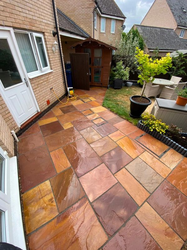 Wet tiled patio with garden shed and outdoor seating.