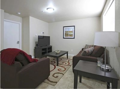 Image of the comfortable living room with couches, chair, and tv