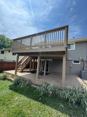 Two-level wooden deck attached to a house with stairs and railing.